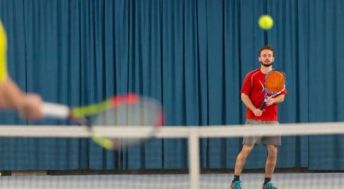 a tennis coach prepares to return a serve at a health club in montrose