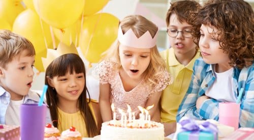 a group of kids celebrate a birthday party wearing colored birthday hats at a children's birthday party venue in montrose