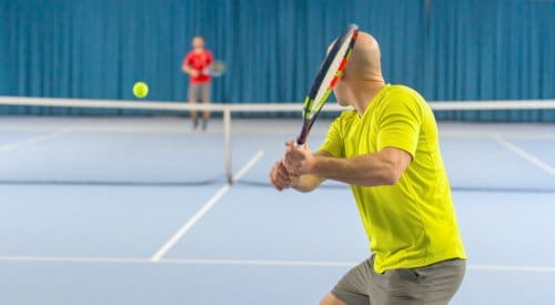 a fitness center member prepares to return a serve at a tennis league in montrose